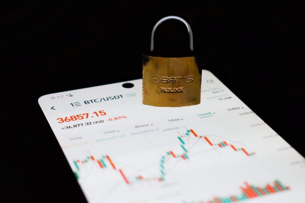 photo-1643962578248-71e90f8d14f3jpg - StakeProSoft Padlock resting on a smartphone showing a BTC/USDT price chart, representing bankroll protection and safety features in casino bots