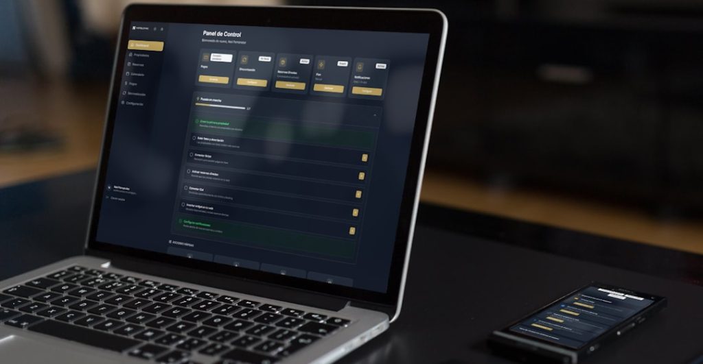 Laptop and phone displaying dark financial dashboard interface representing Stake bot automation software