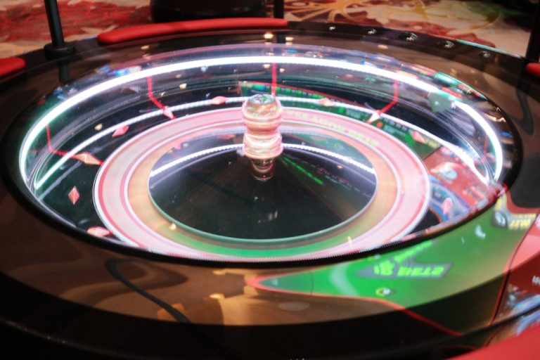 A modern electronic roulette wheel glowing with neon lights, representing AI-powered casino automation